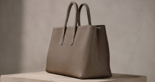 Borsa strutturata senza marchi in pelle color tortora su un piedistallo in pietra